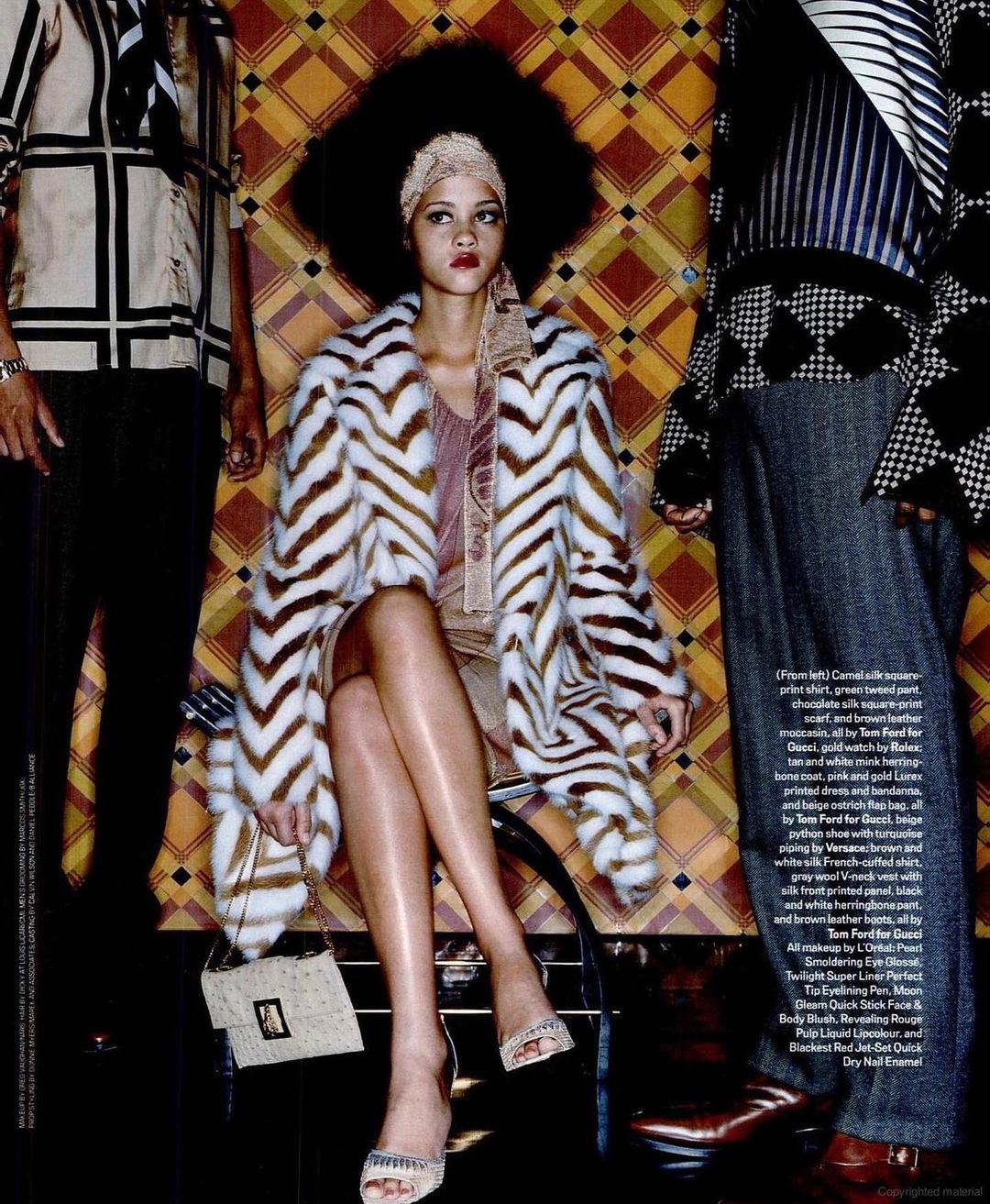 Fashion editorial image: a woman with an afro and zebra-striped coat poses with other models, set against a patterned backdrop.