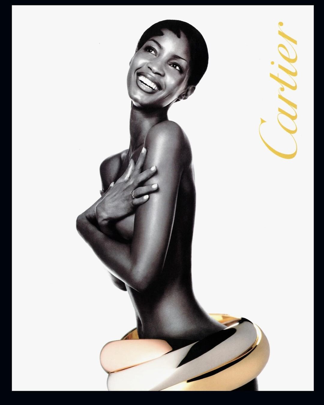 Elegant portrait of an African-American woman with jewelry by Cartier, captured in a monochrome studio setting with gold accents.