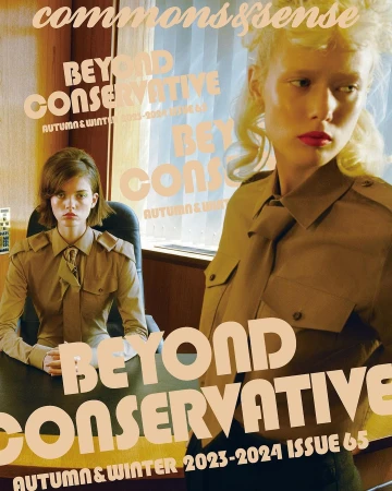 Two female models in khaki military-style shirts posing inside an office setting photographed by Wanda Martin.