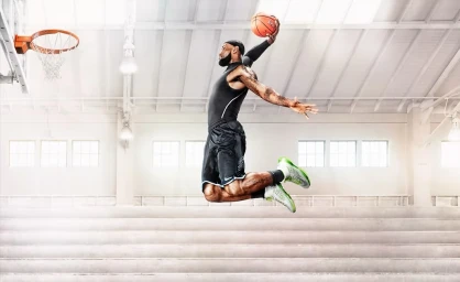 LeBron James in mid-air dunking a basketball inside a gymnasium captured by Warwick Saint