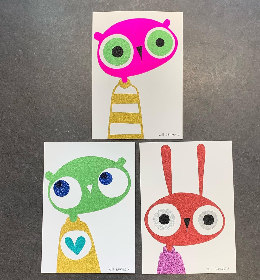 Whimsical art featuring colorful cartoon characters: a pink owl, a green alien, and a red rabbit against a neutral backdrop.