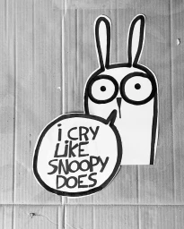 Black and white illustration cut-out of a whimsical cartoon rabbit character with large round eyes and speech bubble