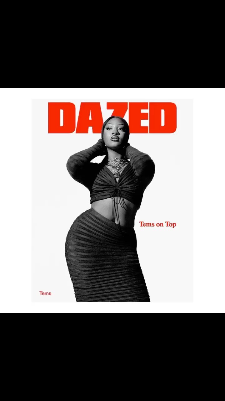 Magazine cover featuring a woman in a black two-piece outfit, necklace, and slicked back hair. The magazine cover has a white background.