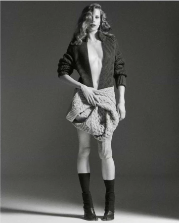 Monochrome fashion portrait by Will Scarborough of a woman in a dark knitted cardigan and twisted cable sweater tied around her waist.