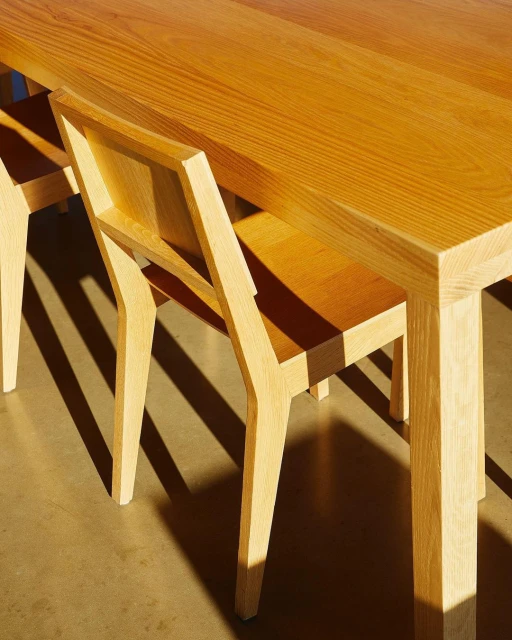 Close up of a light-wood table and chairs set, showcasing the texture of the wood and the clean, modern lines of the furniture.