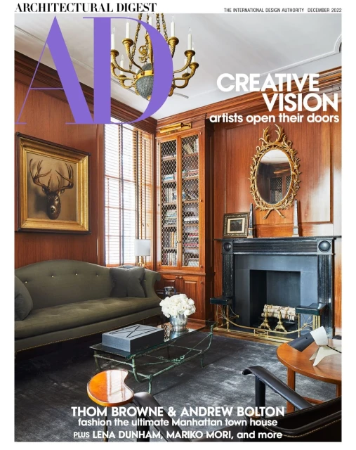 Architectural Digest magazine cover showcases a well-appointed living room interior with a fireplace, bookshelf, and stylish decor elements.