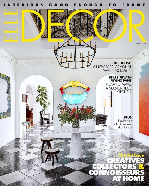 Elle Decor magazine cover featuring a bright interior with a checkered floor, round marble table, and floral arrangement in a modern home.