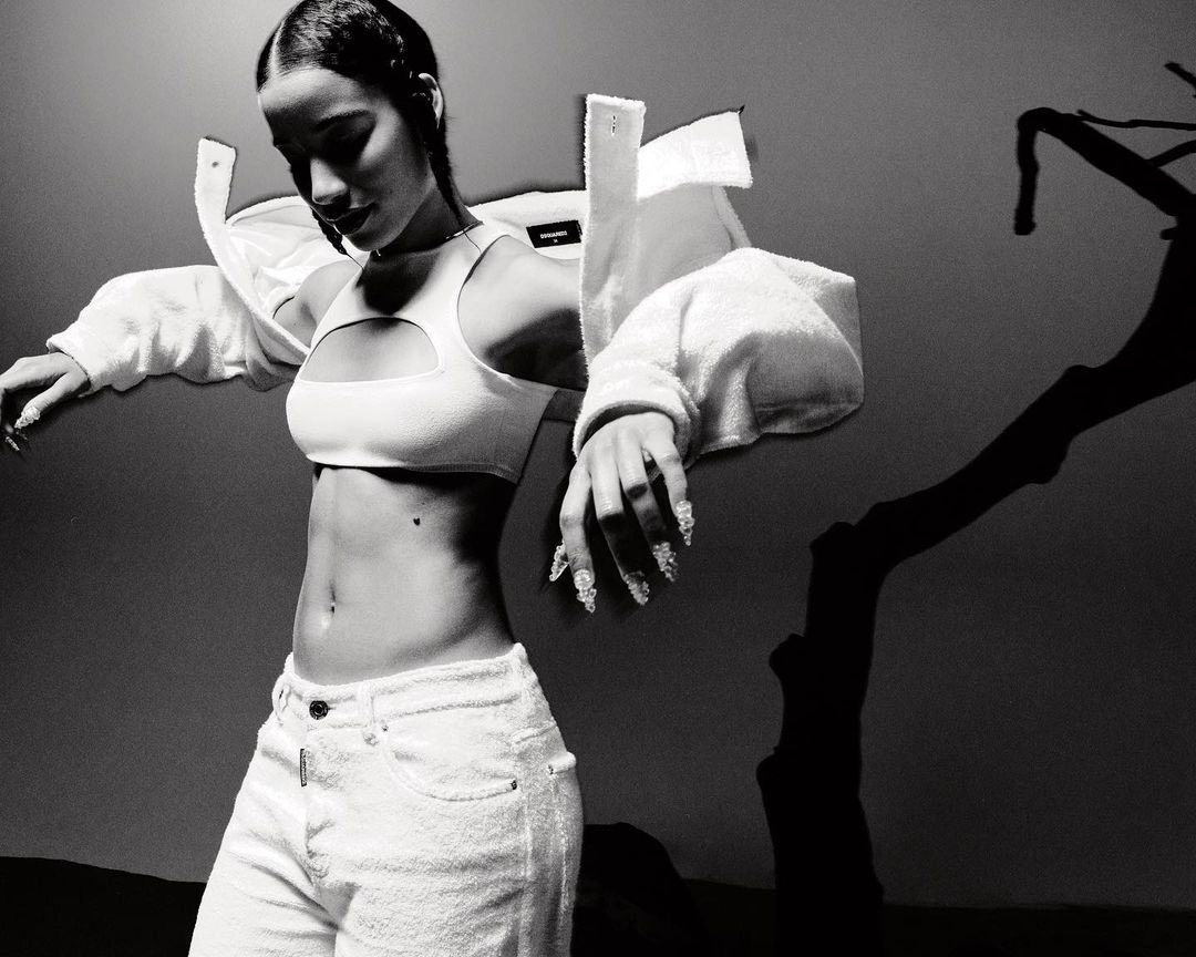 Monochrome fashion portrait of a woman wearing a white cutout crop top and light-colored jeans by William Arcand