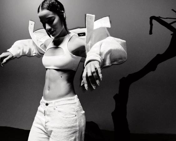 Monochrome fashion portrait of a woman wearing a white cutout crop top and light-colored jeans by William Arcand
