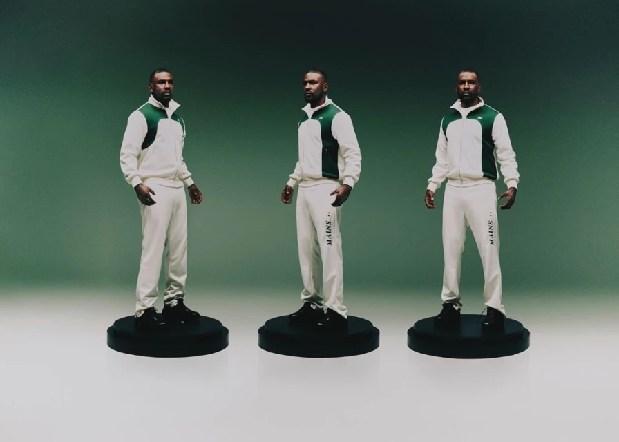 Three identical adult male figures wearing matching white and green tracksuits on pedestals, set against a graduated green backdrop.