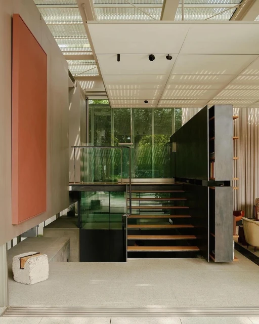 View of a modern interior featuring an open-plan staircase, neutral color scheme, contemporary furniture, and large painting.