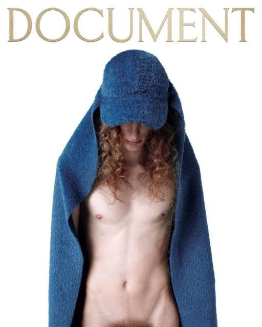 Nude figure with curly hair poses under a blue hooded blanket. The magazine cover is on a white background with the word "DOCUMENT" at the top.