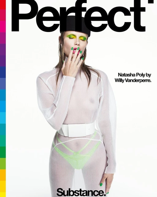 Magazine cover featuring a model with green makeup and nail polish, wearing a sheer white top and black hat against a white background.