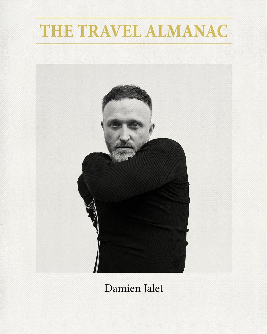 Black and white portrait of a man wearing a black top against a light background, on the cover of a book titled 'The Travel Almanac'.