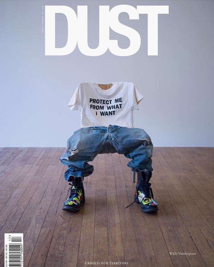 Dust magazine cover featuring a white t-shirt with text, blue jeans, black boots, and a wooden floor in a brightly lit studio.