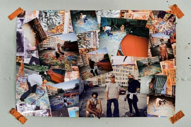 A physical photo collage pinned to a textured wall with orange tape, featuring multiple street and urban photography prints.