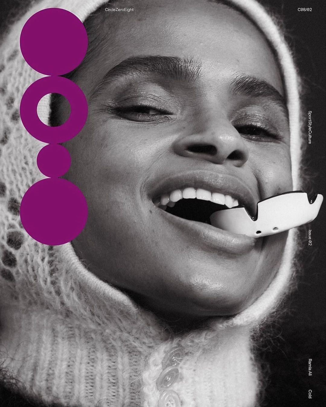 Black and white studio shot of a smiling woman with an egg-shaped object in her mouth, wearing a knitted cap, and a graphic design element.