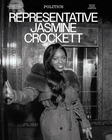 Portrait of Jasmine Crockett in trench coat with fur collar standing in front of elevator in black and white for magazine cover.