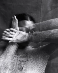 Portrait of a woman with hands covering her face showing multiple exposure motion blur by Xavier Scott Marshall.