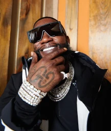 Gucci Mane wearing oversized sunglasses, diamond bracelets, and layered chains photographed by Xavier Scott Marshall.