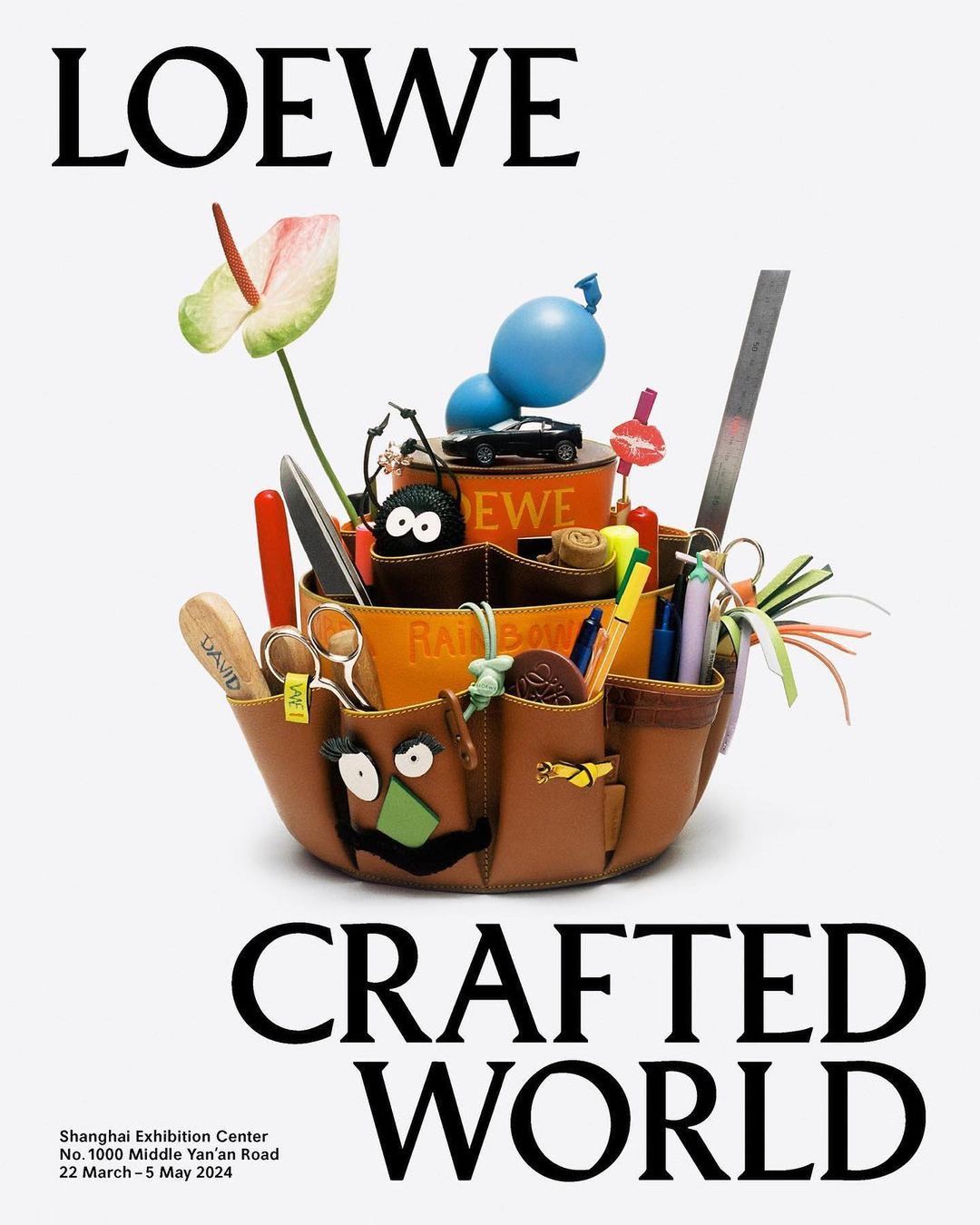 Loewe Crafted World ad with a leather container holding tools and toys, set against a plain background, promoting an exhibit.