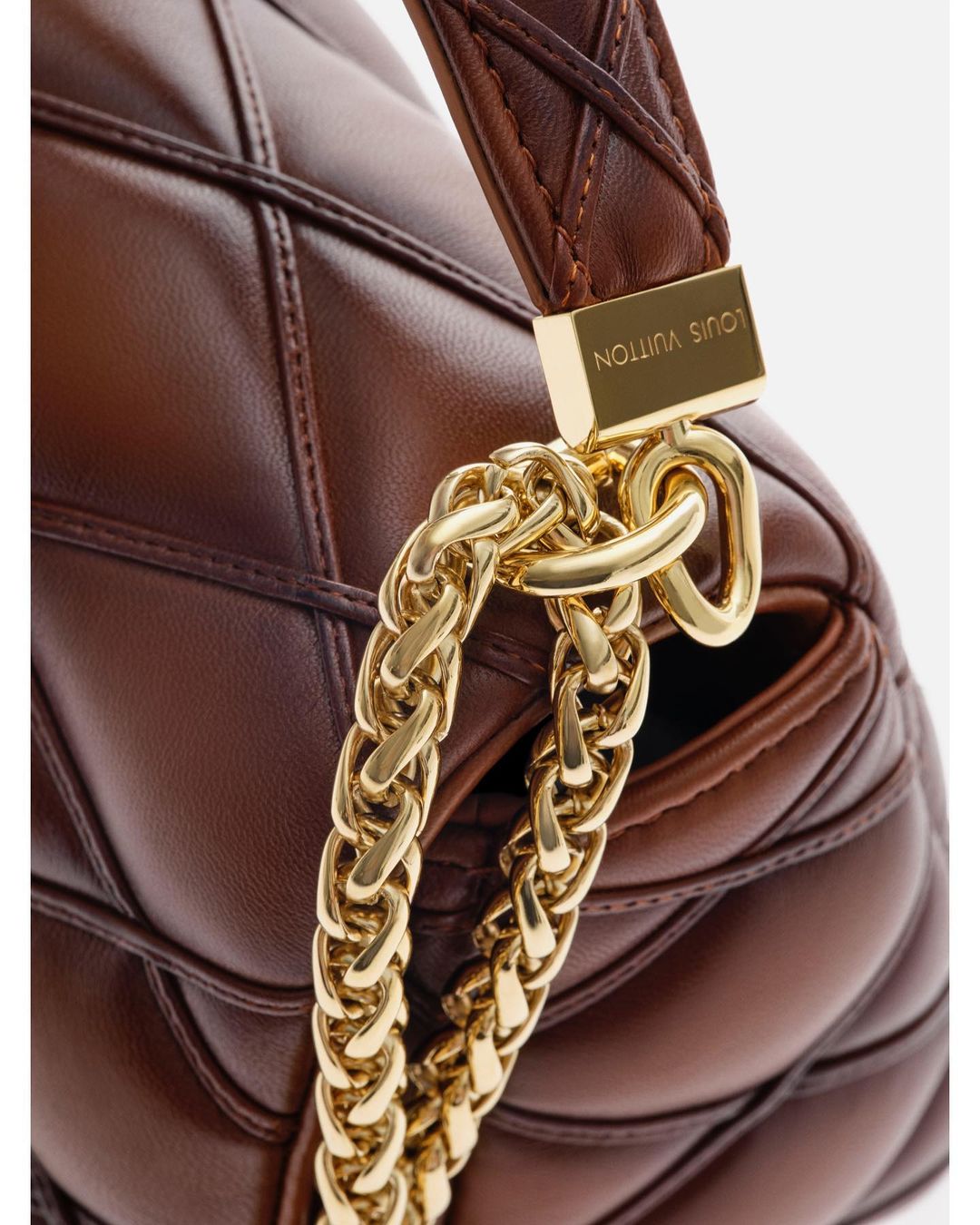 Brown quilted leather Louis Vuitton bag with a gold chain strap and gold hardware, close-up studio product shot for fashion accessories.