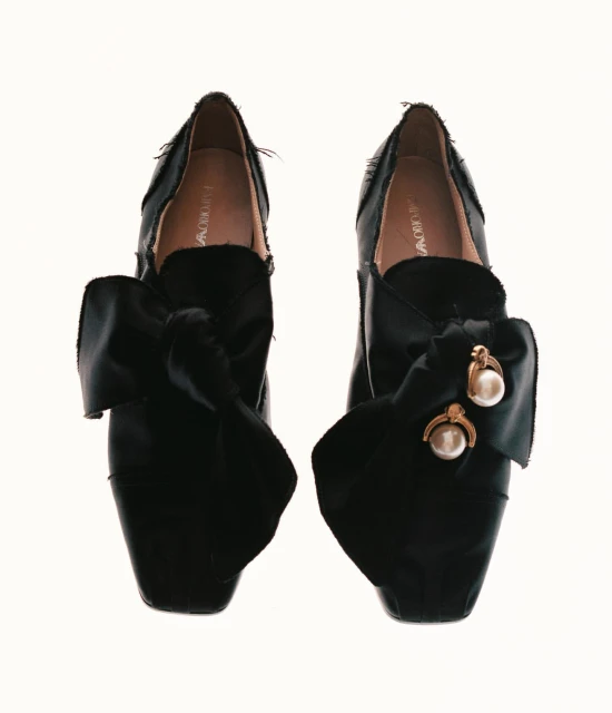 Elegant black Emporio Armani shoes featuring large satin bows with pearl and gold-tone accents, photographed on a clean white background.