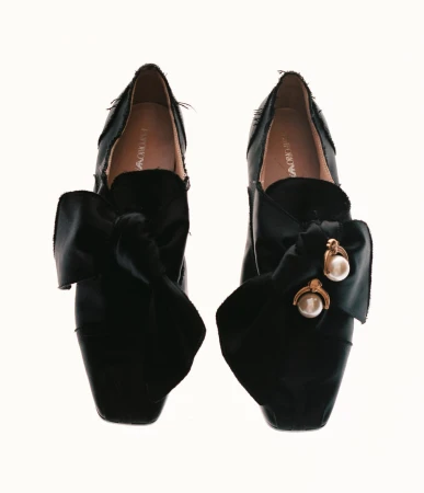 Elegant black Emporio Armani shoes featuring large satin bows with pearl and gold-tone accents, photographed on a clean white background.