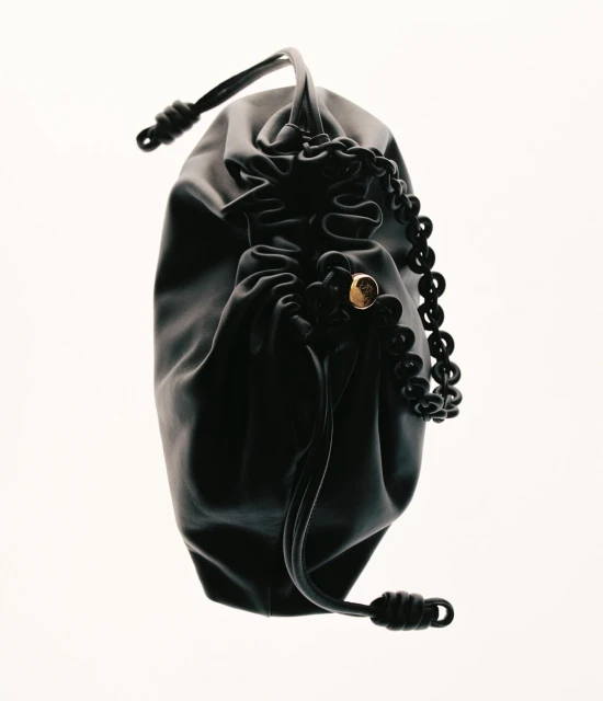 Elegant black satin drawstring pouch or handbag with a decorative gold accent and a black beaded strap against a white background.