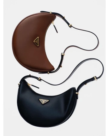 Two Prada Cleo handbags in black and brown leather with shoulder straps and a triangular logo, displayed on a white background.
