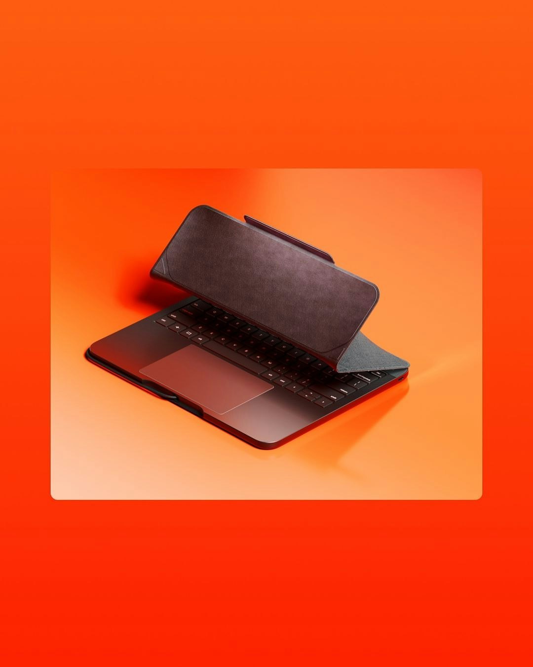 Laptop with a black cover partially open on a bright orange surface. The cover is angled, revealing the keyboard and touchpad beneath.