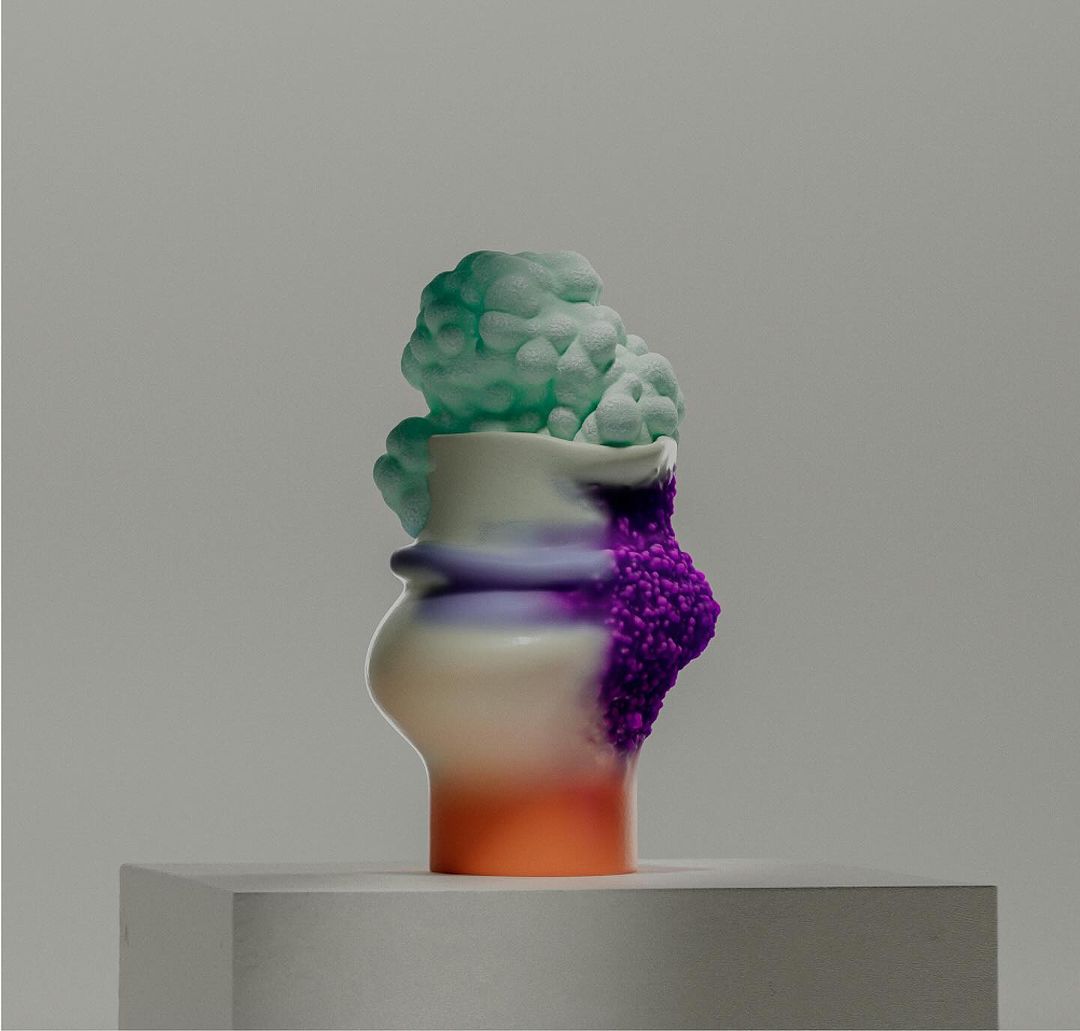 Colorful abstract art sculpture on a white plinth against a grey background features rounded shapes and blended colors for a modern aesthetic.