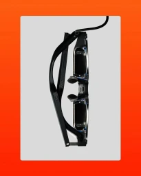 Close-up profile view of sleek black smart glasses set against a white backdrop framed in vibrant orange.