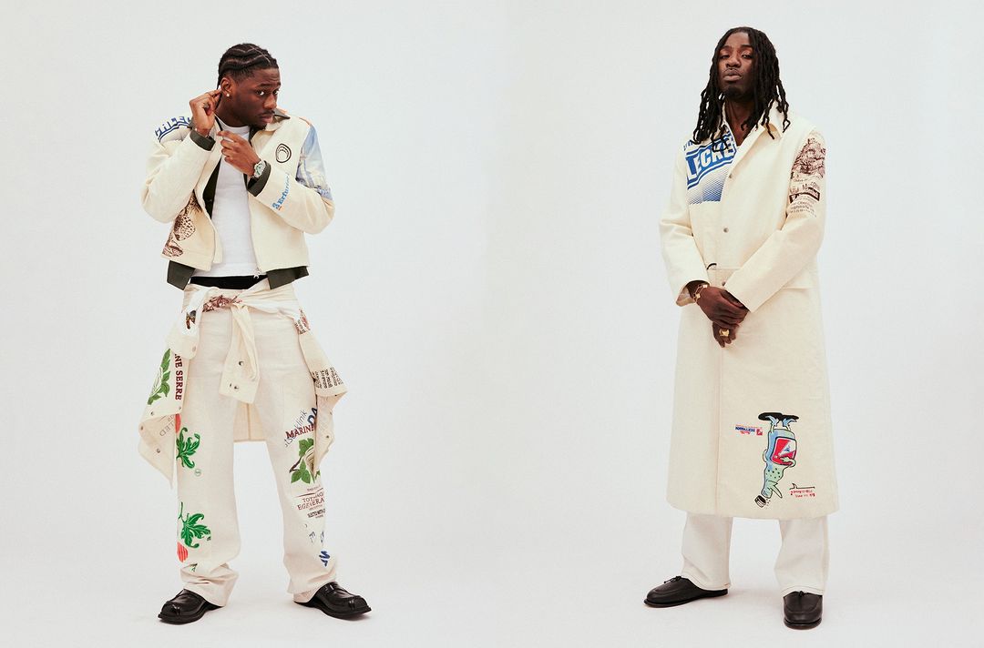 Two adult men in patterned outerwear and pants pose in a studio setting with a white backdrop, showcasing fashion and style.
