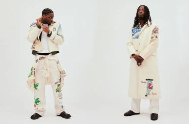 Two black men posing against a white background, wearing cream-colored graphic print jackets and trousers.