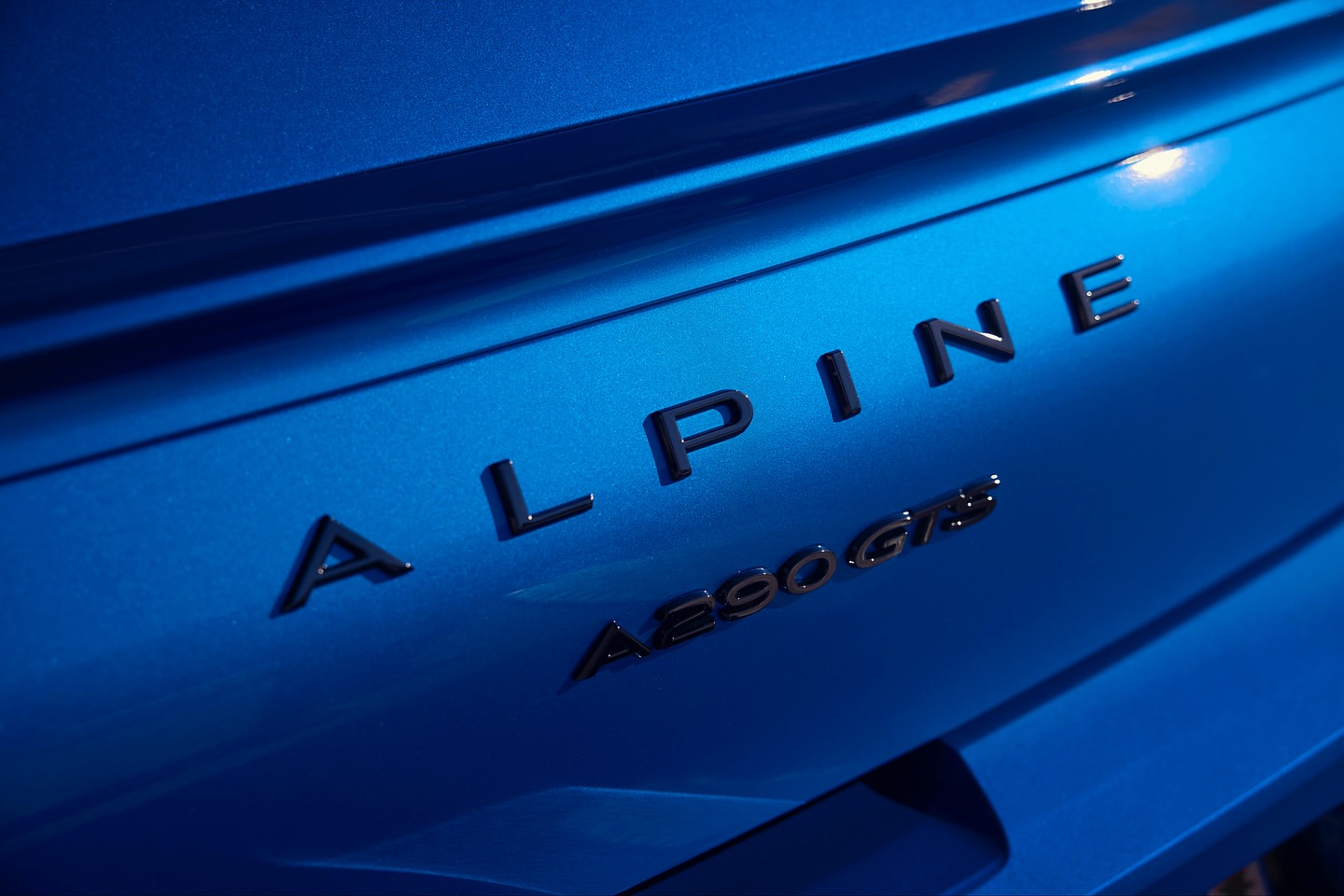 Close-up of blue Alpine A290 GTS car detail. The car's smooth, reflective surface shows clean lines and modern automotive design.