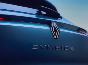 Close-up of a blue Renault Symbioz car rear badge and lettering under a clear sky.
