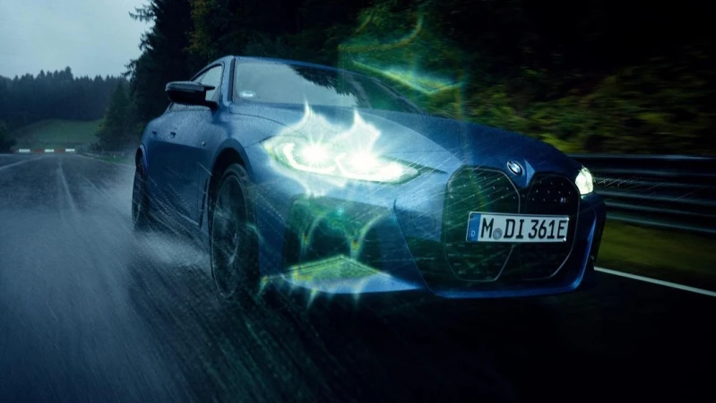 Blue BMW car on a wet road, enhanced with digital effects emphasizing the headlights and front design, showcasing automotive technology.