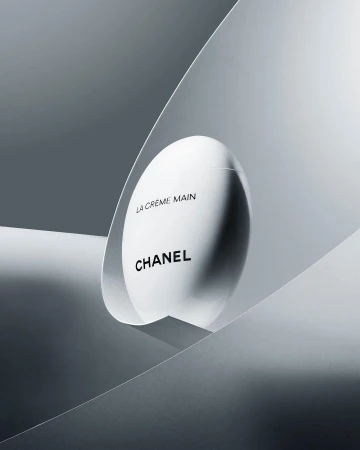 Chanel hand cream product shot. Minimalist composition featuring sleek packaging against a gradient gray backdrop. Beauty and luxury.
