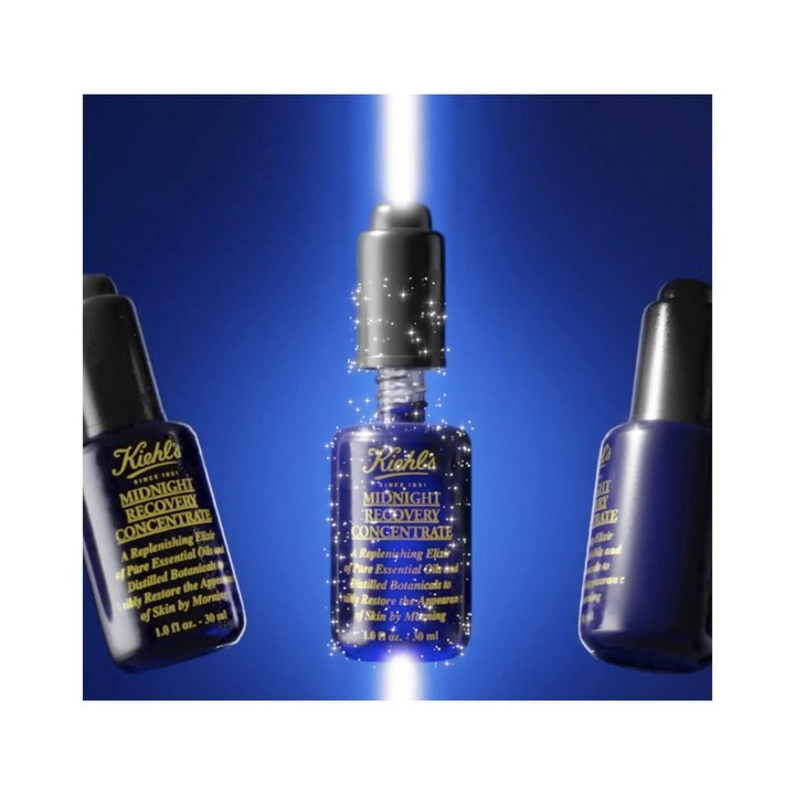 Three bottles of Kiehl's Midnight Recovery Concentrate are arranged against a blue background with a light ray shining down.