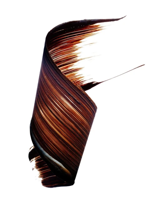 Abstract swirl of brown makeup product on white background. Beauty shot of dark, glossy cream creating a dynamic swirl effect.