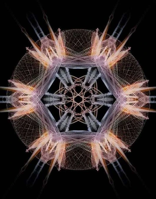 Intricate starburst pattern with radiating lines and geometric shapes in shades of peach, grey, and white against a dark background.