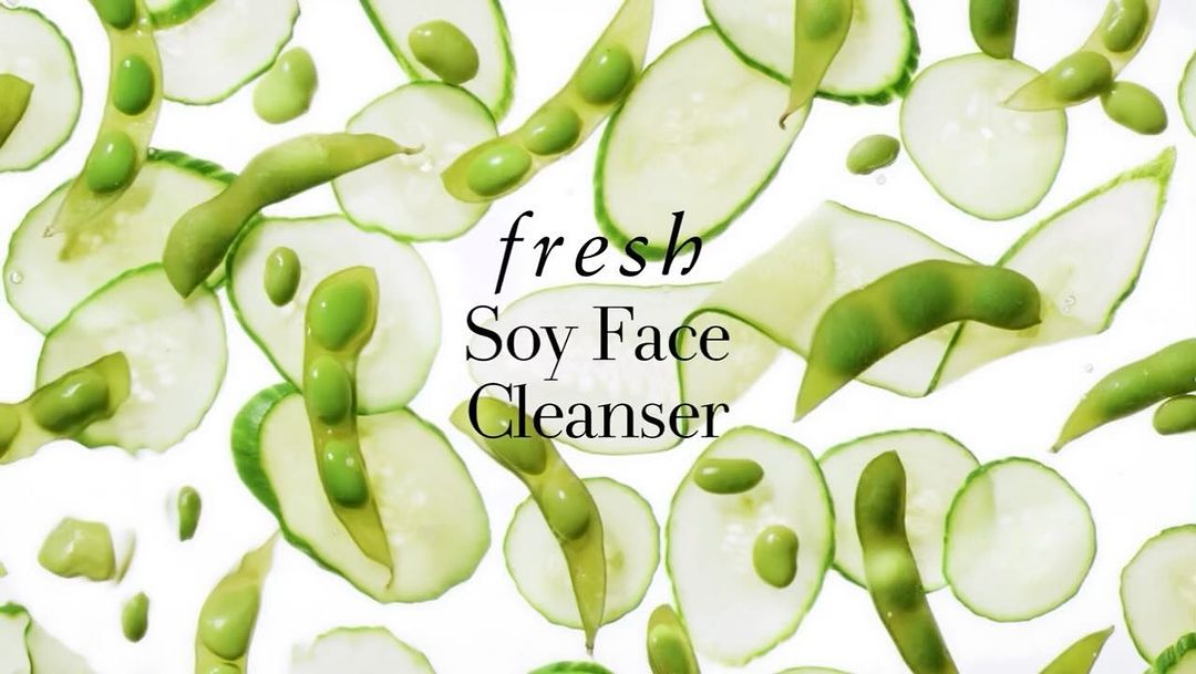 Overhead shot of sliced cucumbers and edamame pods on a white backdrop, accentuating natural ingredients and the skincare product's purity.