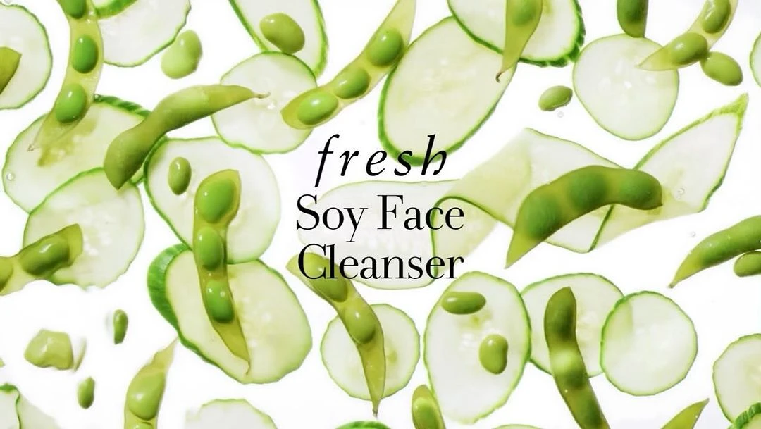 Overhead shot of sliced cucumbers and edamame pods on a white backdrop, accentuating natural ingredients and the skincare product's purity.