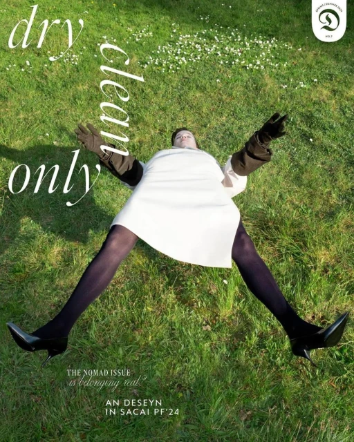 Fashion magazine cover shot: Model lies on green grass wearing a white dress, dark gloves, black tights and shoes; "Dry Clean Only" text.