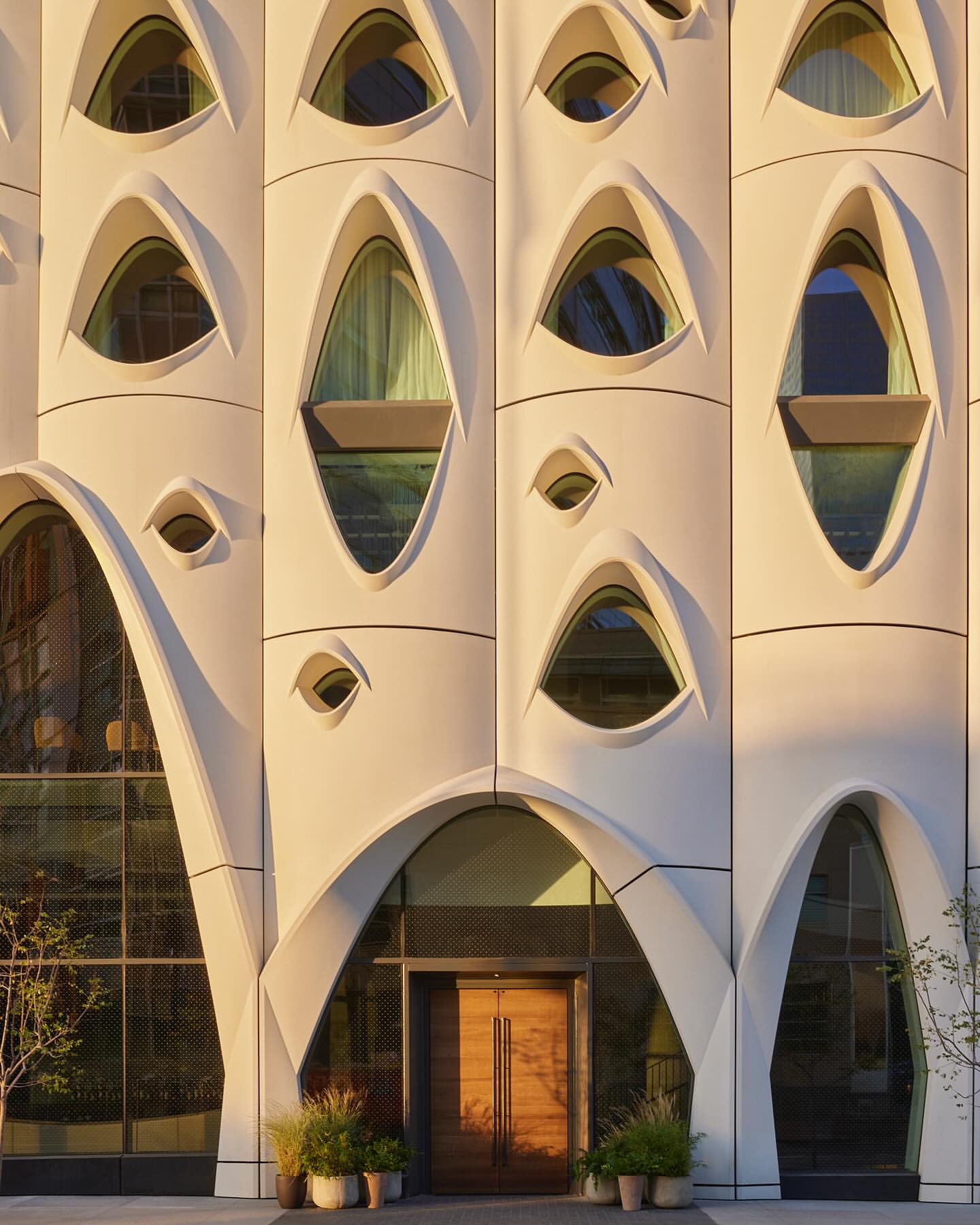 Exterior architecture featuring a distinctive building facade with oval windows and an arched entrance. A modern and artistic design.