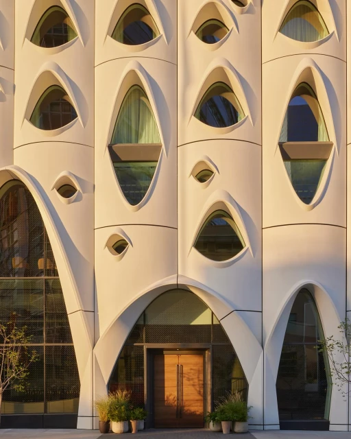 Exterior architecture featuring a distinctive building facade with oval windows and an arched entrance. A modern and artistic design.