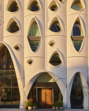 Exterior architecture featuring a distinctive building facade with oval windows and an arched entrance. A modern and artistic design.