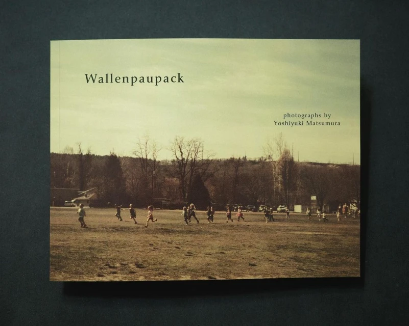Book cover featuring a vintage-toned photograph of a children's sports game on a field with trees and a cloudy sky in the background.