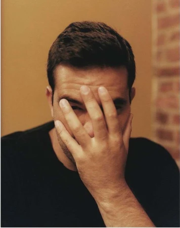 Close-up portrait of a man covering his face with his hand by photographer Yoshiyuki Matsumura